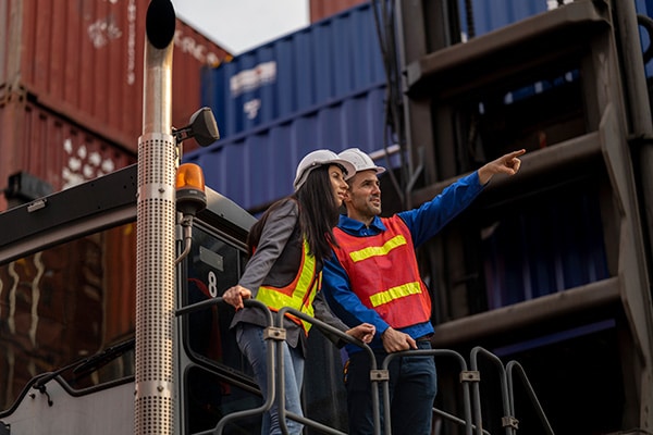 two intl logistics employees surveying ocean shipments